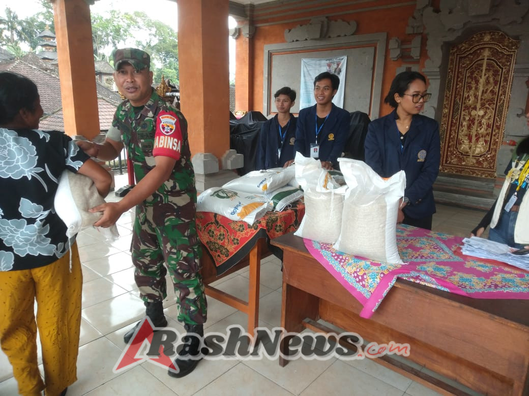 Babinsa Kedisan Serda I Kadek Wardana Kawal Penyaluran 540 Paket Beras ke 270 KK