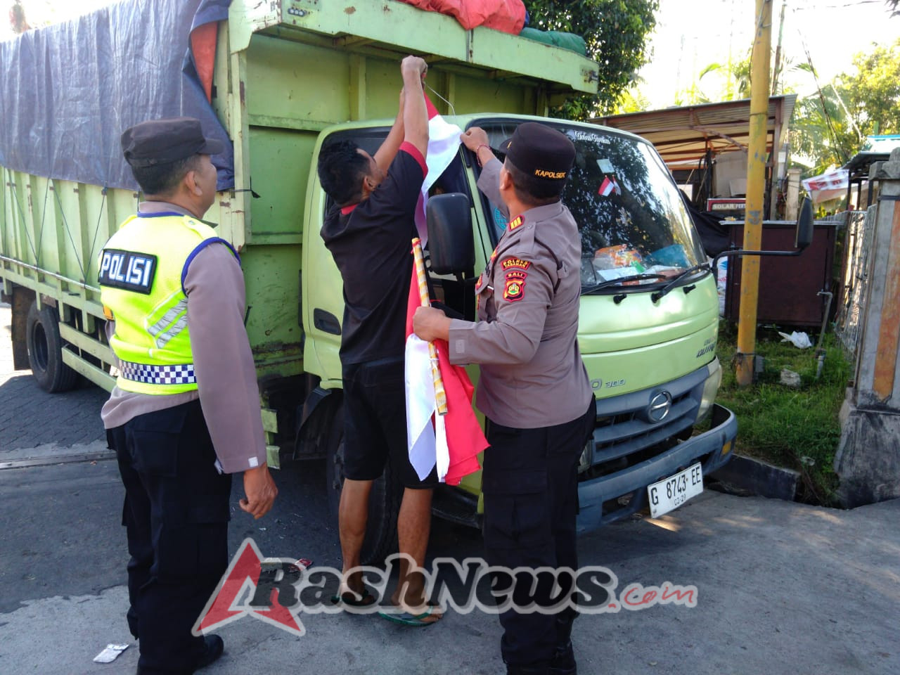 Kapolsek Kerambitan Membagikan Bendera Merah Putih kepada para Pengemudi Kendaraan.