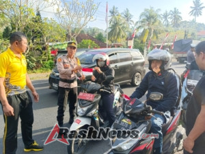 Pupuk Rasa Nasionalisme, Polsek Manggis Bagikan Bendera Merah Putih Kepada Pengendara Motor.