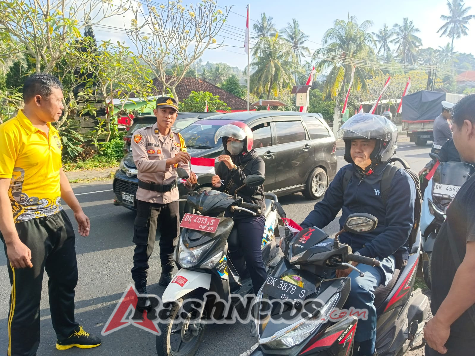 Pupuk Rasa Nasionalisme, Polsek Manggis Bagikan Bendera Merah Putih Kepada Pengendara Motor.