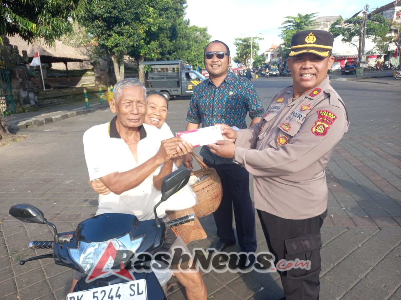 Kapolsek Mengwi Bagikan Bendera Merah Putih Kepada Warga