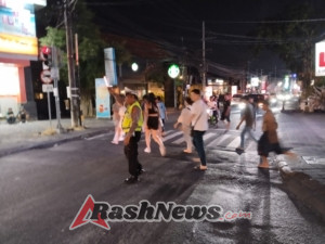 Personel Lalu Lintas Polsek Kuta Utara Sigap Sebrangkan Warga Di Simpang Lio Kerobokan