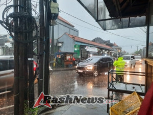 Diguyur Hujan, Personil Lalu Lintas Polsek Mengwi Tetap Lakukan Pengaturan di Jalur Macet