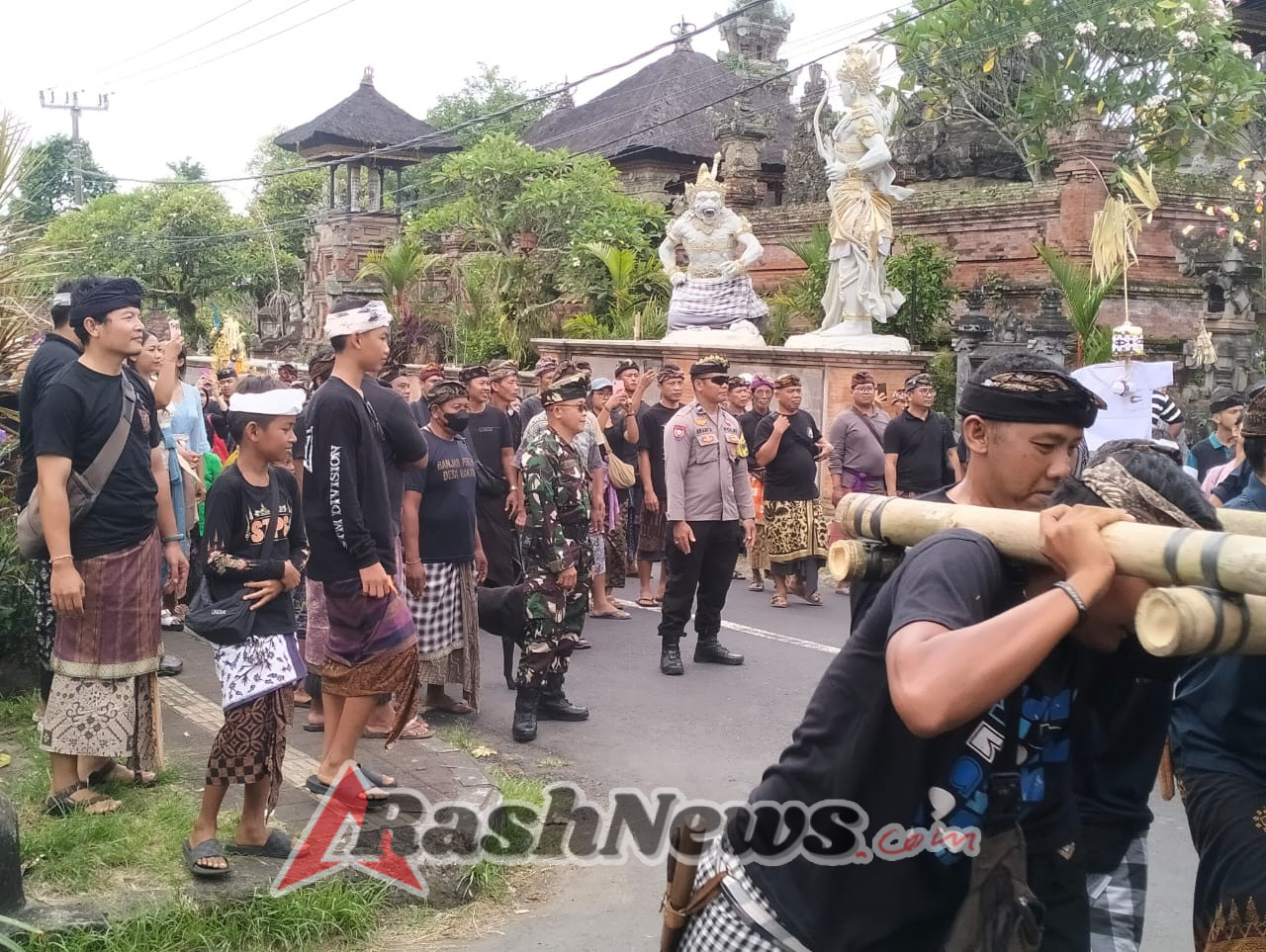 Bhabinkamtibmas Desa Bakas Amankan Upacara Ngaben di Simpang Empat Bakas.