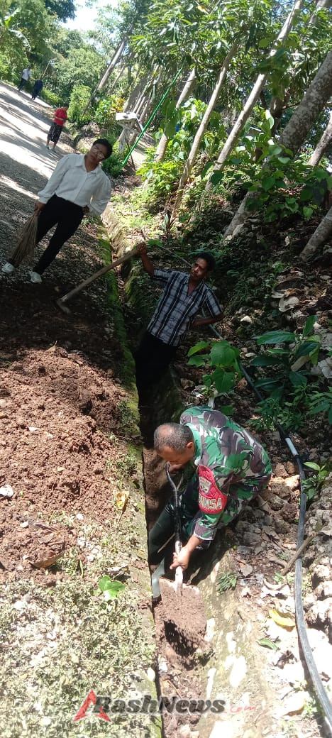 Kerja Bakti Bersama Staf Desa Kuatae Babinsa Serda Agus Takesan Bersihkan Saluran Drainase
