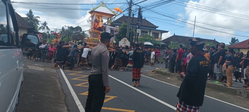 Bhabinkamtibmas Desa Tohpati Bersinergi dengan Pecalang Amankan Prosesi Pengabenan.