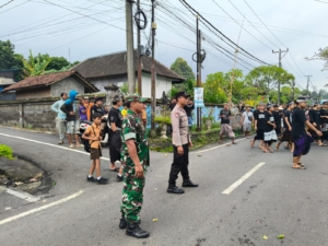 Jaga Kelancaran Tradisi Adat, Babinsa Temesi Amankan Lalulintas Upacara Pitra Yadnya