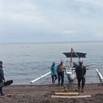 Personil Satuan Polairud Polres Karangasem Bantu Warga Nelayan Mendorong Jukung