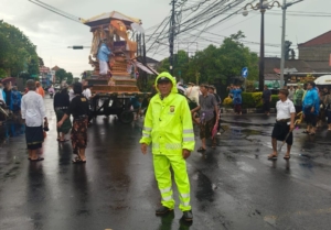 Cuaca Tak Bersahabat, Bhabinkamtibmas Polsek Dentim Pastikan Prosesi Ngaben Berjalan Aman dan Lancar