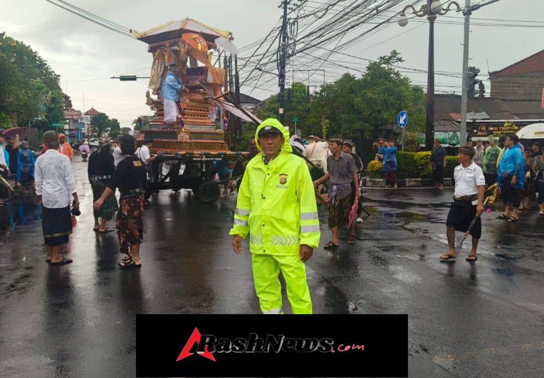 Cuaca Tak Bersahabat, Bhabinkamtibmas Polsek Dentim Pastikan Prosesi Ngaben Berjalan Aman dan Lancar