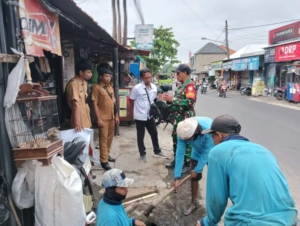 Babinsa Turun Langsung Ingatkan Warga Jaga Lingkungan Saat Pembersihan Gorong-Gorong di Denpasar Barat