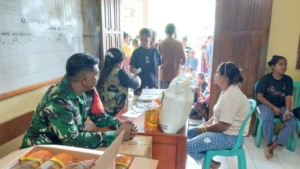 Babinsa Dampingi Pembagian Bantuan Pangan di Desa Tana Duen