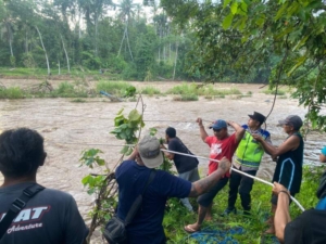 Personil Polsek Selemadeg Barat bersama warga berhasil mengevakuasi warga yang terjebak di aliran Sungai Balian