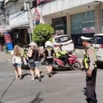 Anggota Lantas Polsek Kuta Utara Atur Lalin dan Bantu Penyeberangan di Simpang Batu Belig.