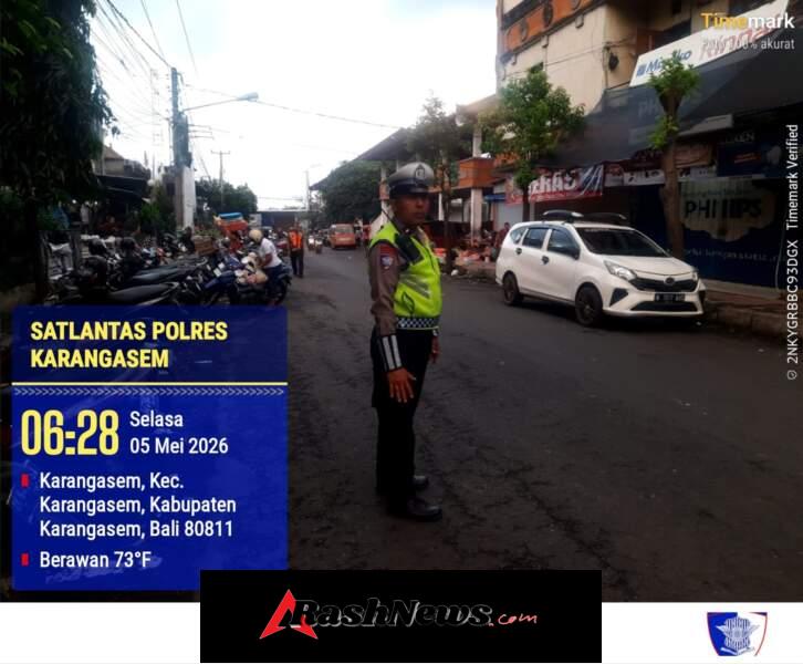 Anggota Polres Karangasem Laksanakan Tugas Menyebrangkan Pejalan Kaki di Pasar Kesatriaan Amlapura