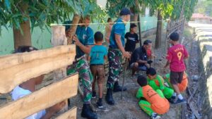 Yonarmed 12 Kostrad Gotong Royong Bersama Warga Bangun Pagar SDN Nanaeklot di Perbatasan